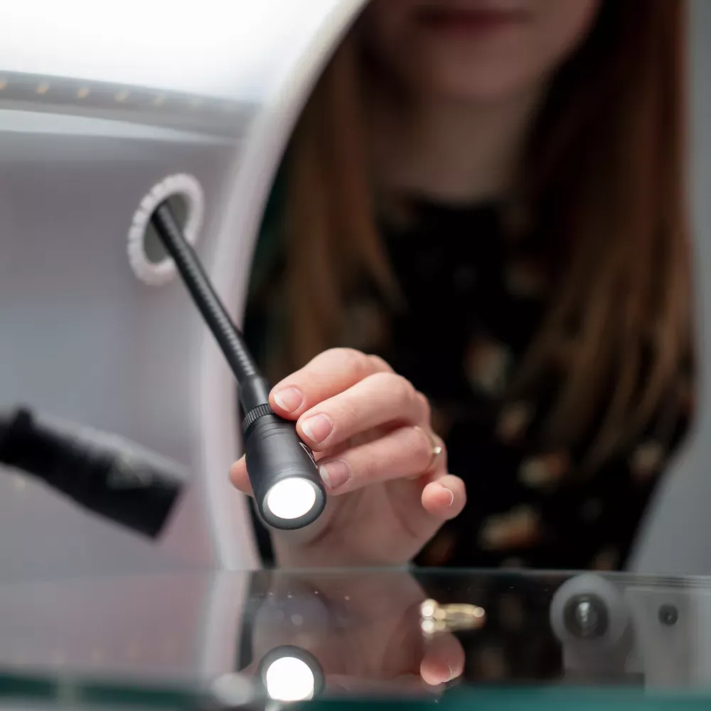 Woman Adjusting LED Light Jewelry Photography Setup